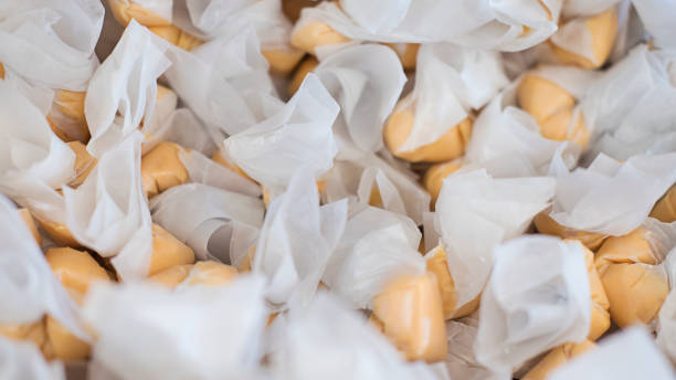 pila de chicloso de agua salada, delicioso y suave, envuelto en papel encerado en una tienda de caramelos en san francisco, california - taffy fotografías e imágenes de stock