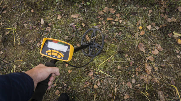 istock a man with a metal detector is looking for a treasure 871284502