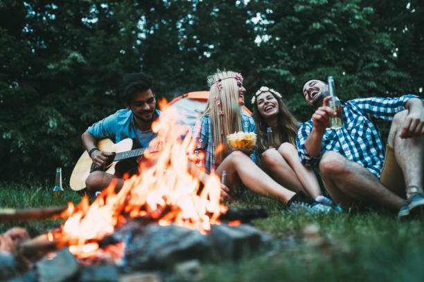 istock Cheerful young friends having fun by campfire 871285714