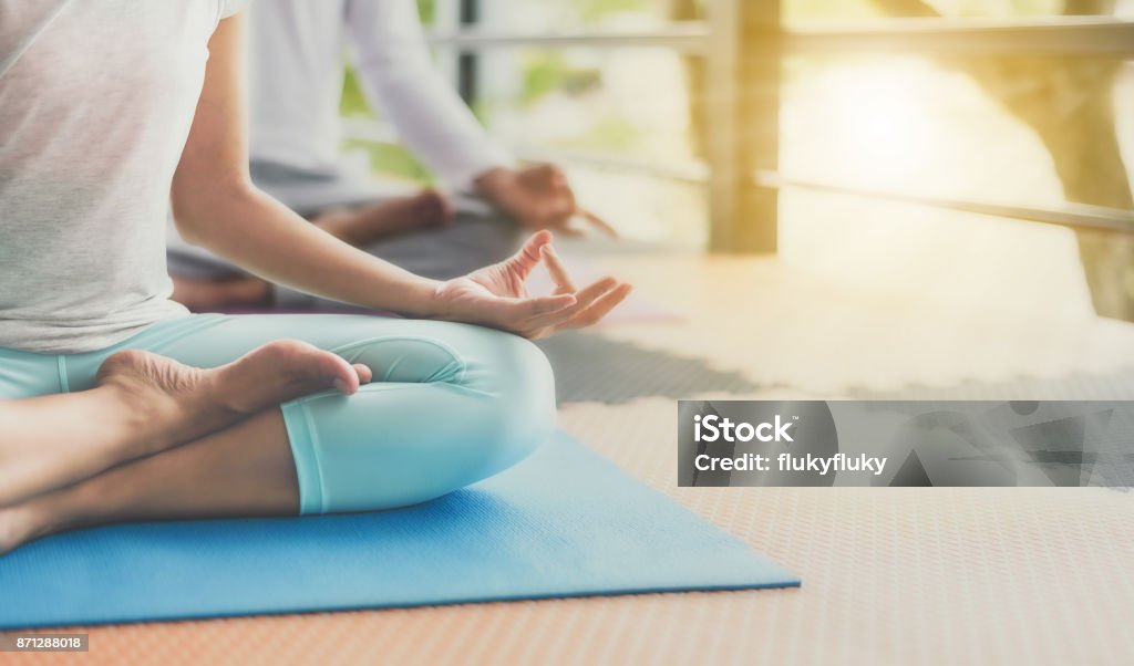 Young people are meditating on colorful tires for good health. Yoga Stock Photo