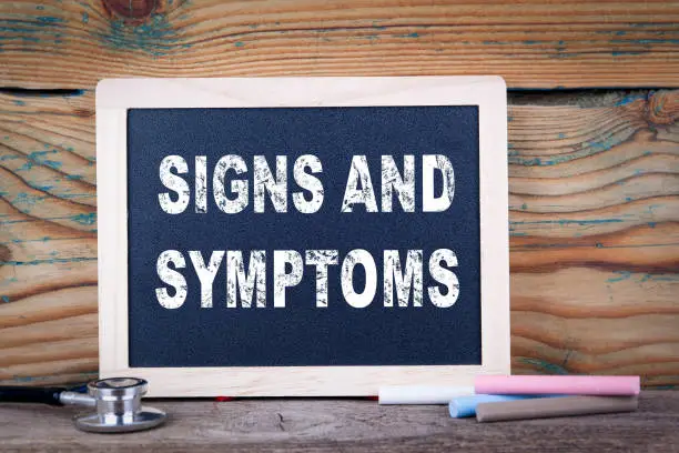 Photo of signs and symptoms. Chalkboard on a wooden background