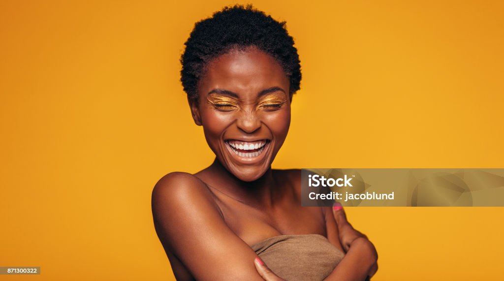 Afrikanische Frau lachend vor gelbem Hintergrund - Lizenzfrei Afrikanischer Abstammung Stock-Foto