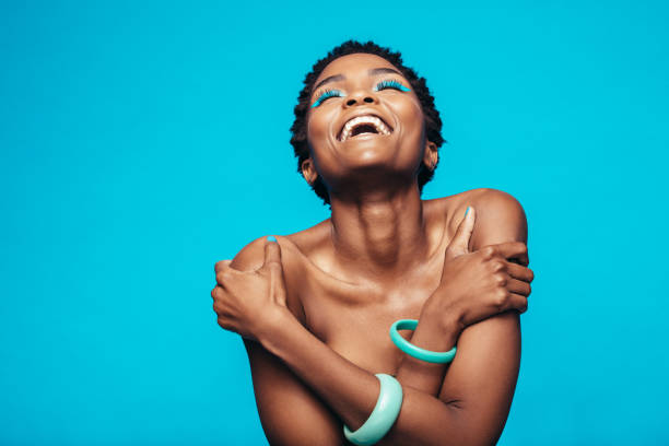 istock African woman with vivid makeup hugging herself 871300472