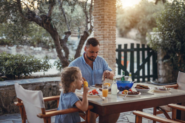 istock Father and dauther having mediterranean dinner on a terrace 871300660