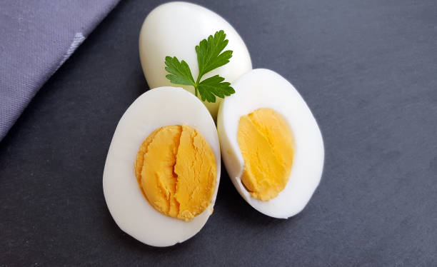 uova sode su sfondo scuro - hard cooked egg foto e immagini stock