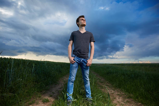 istock Teenager standing in a wheat field at sunset 871304514