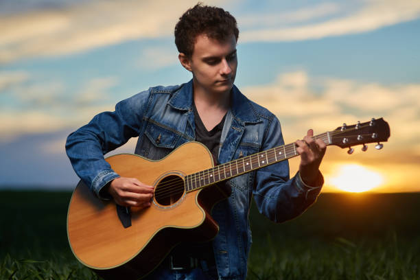 istock Teenager playing guitar at sunset 871304554