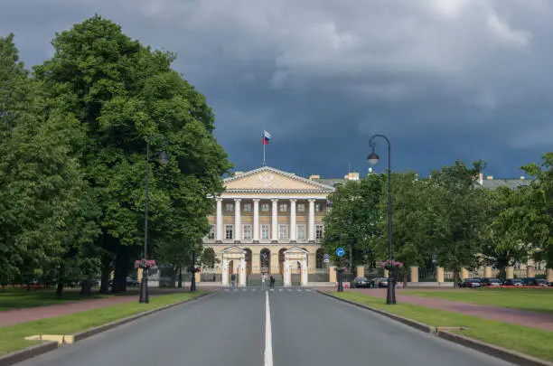 Photo of Facade of the Smolny Institute (the official residence of the governor of St.Peterburg now) with a Lenin statue in the foreground. Russia