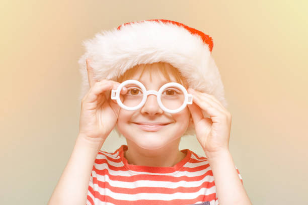 istock Boy is wearing Santa's glasses and hat. Portrait 871311336