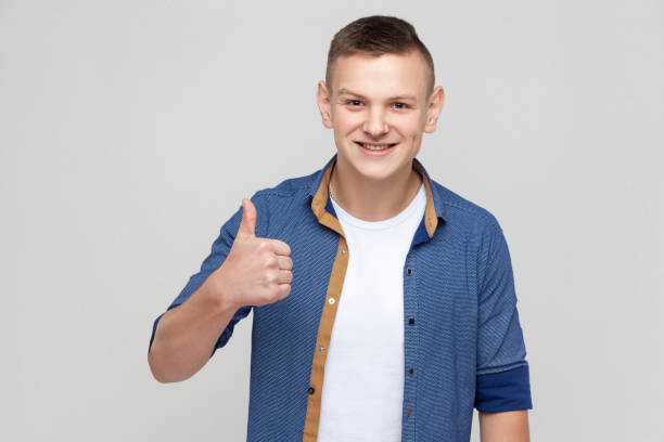 istock Like sign. Expression boy thumbs up, looking at camera and toothy smile 871323806