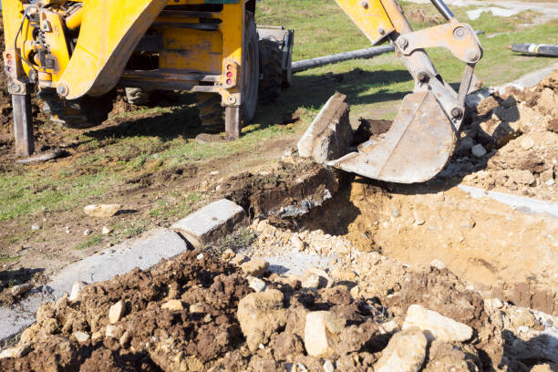 istock Earth mover digging trench across asphalt street 871335006