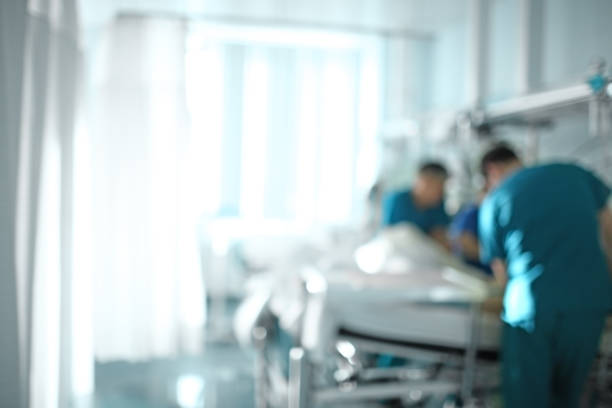 Medical doctor team at the bedside of patient, unfocused background Medical doctor team at the bedside of patient, unfocused background. intensive care unit stock pictures, royalty-free photos & images