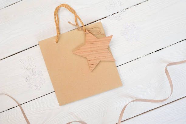 istock mockup Christmas composition kraft package on wooden white background. Flat lay, top view 871336422