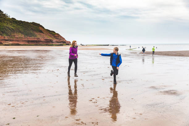 istock Sister chasing little brother at seaside and having fun 871339068