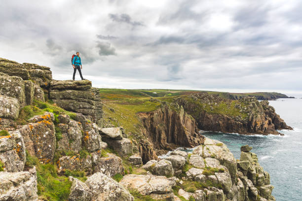 istock Man standing on a rock cliff enjoying the view 871339460