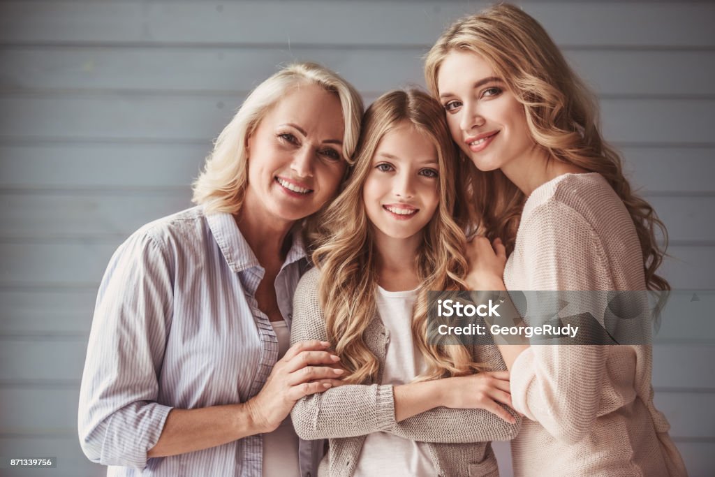 Granny, mom and daughter Beautiful women generation: granny, mom and daughter are hugging, looking at camera and smiling Mother Stock Photo