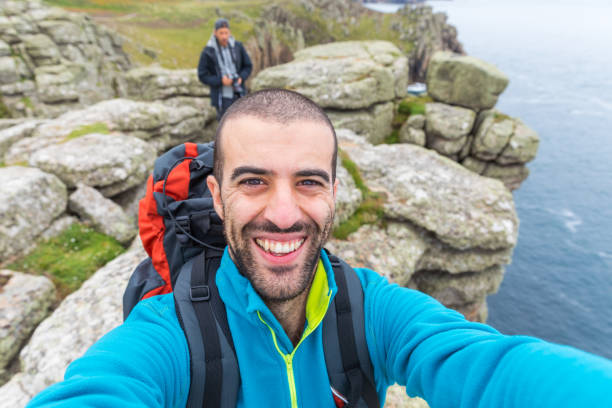 istock Man hiking and taking a selfie on top of cliffs 871339836