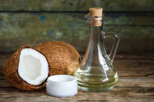 istock Coconuts with coconut oil on wooden background 871342422