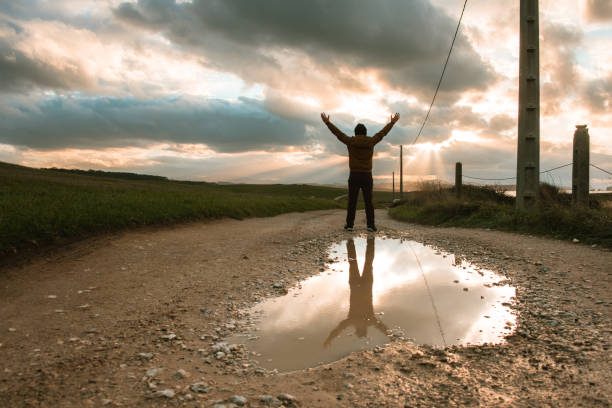 istock Man with arms raised at sunset 871342454