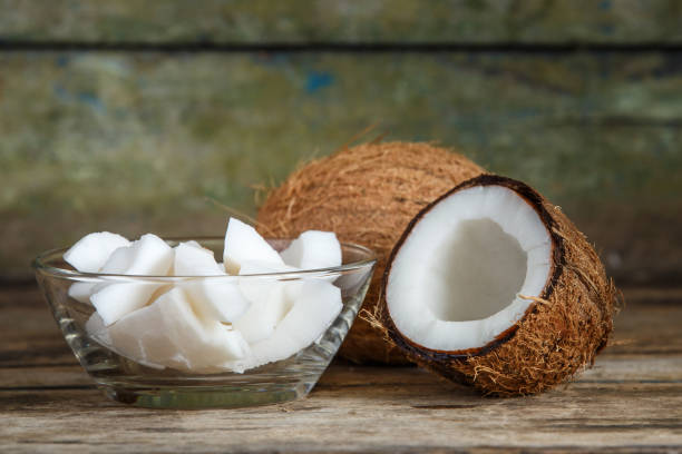 istock Fresh whole and cut in half coconut on wood table 871342548