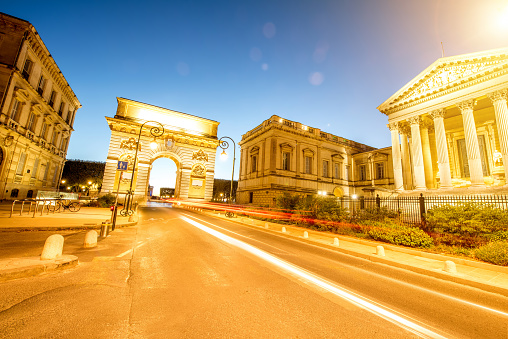 Street view with famous Triumphal Arch on the Foch boulevard during the evening light in Montpellier city in Occitanie region of France