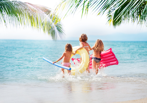 Three girls running in the sea at tropical beach