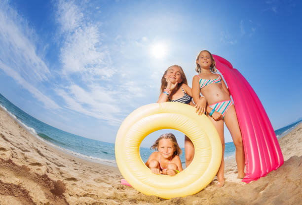 istock Three happy girls friends playing at sandy beach 871345998