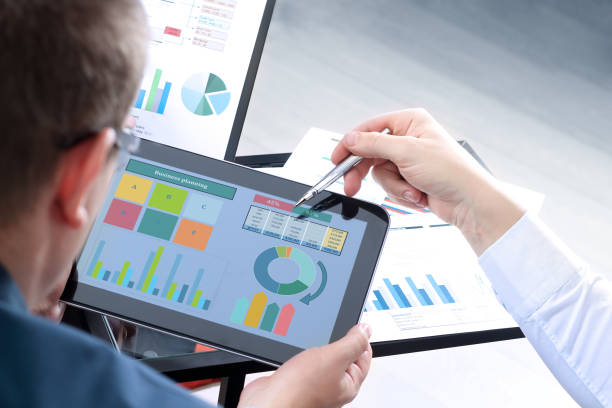 istock Business colleagues working and analyzing financial figures / graphs on a digital tablet 871346338