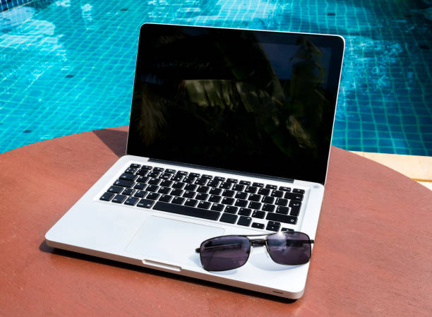 istock Laptop with sunglasses near the pool 871349886