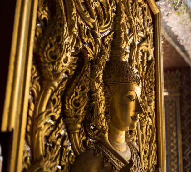 Gold Buddha statue on the door of temple
