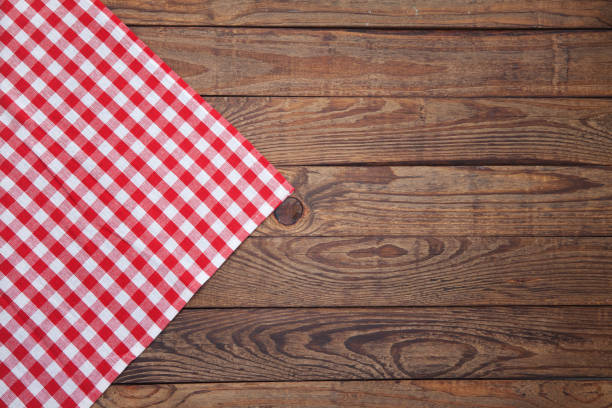 Old vintage wooden table with a red checkered tablecloth. Top view mockup. Old vintage wooden table with a red checkered tablecloth. Top view mock up. tablecloth photos stock pictures, royalty-free photos & images