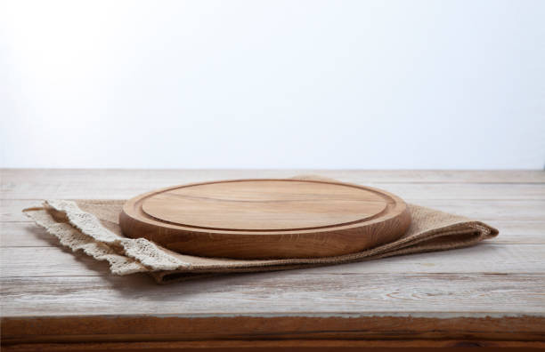 Pizza board, canvas napkin with lace on wooden table. Top view mock up