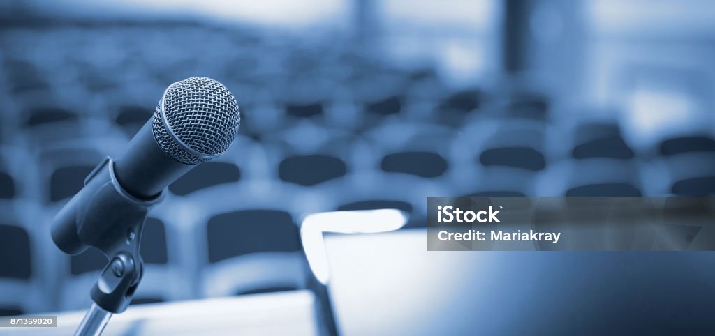 Rostrum in conference hall Rostrum with microphone and computer in conference hallRostrum with microphone and computer in conference hall Press Conference Stock Photo