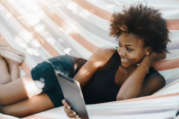 istock Brazilian girl with digital pad on hammock 871362232