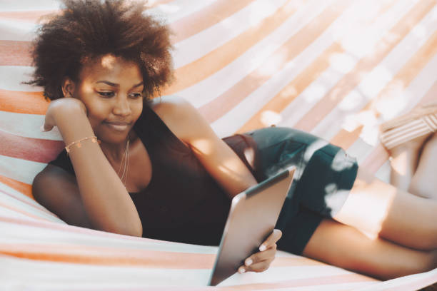 Afro girl on hammock with digital pad