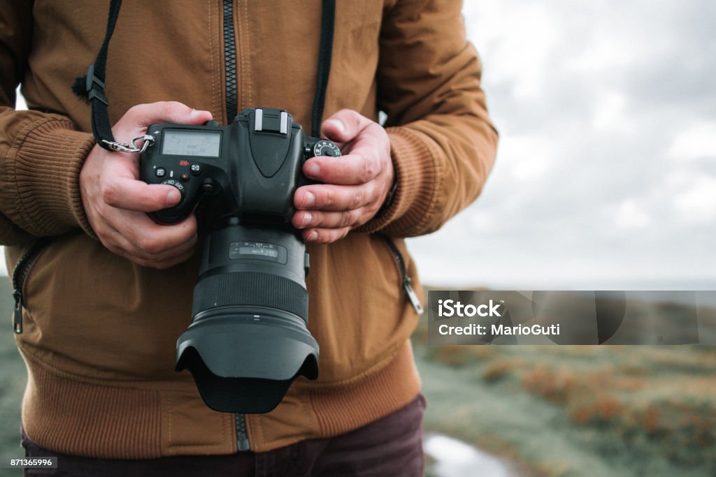 Holding a DSLR camera Two hands holding a modern DSLR camera. Large Stock Photo