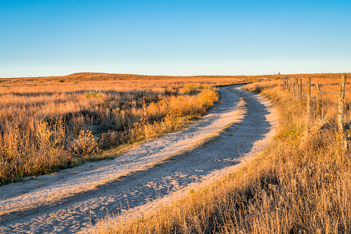 dirt ranch road in prairie of western Kansas near Castle Rock at sunrise