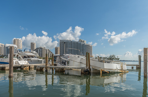 Damaged nautical vessel by tropical hurricane at Miami downtown marina.