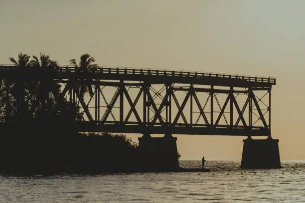 Old Bridge at Bahia Honda State Park in Florida Keys with a man fishing on the sunset