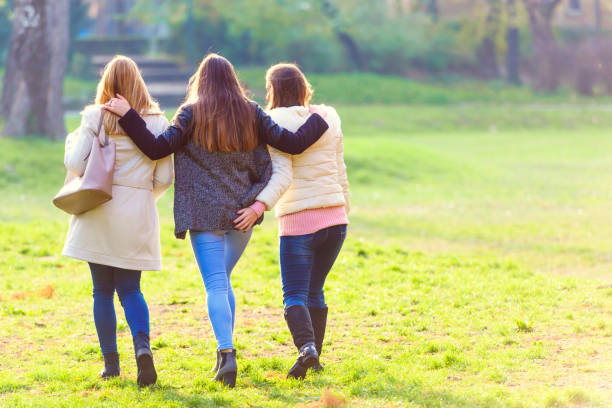 istock Three female friends walking in spring park 871373024
