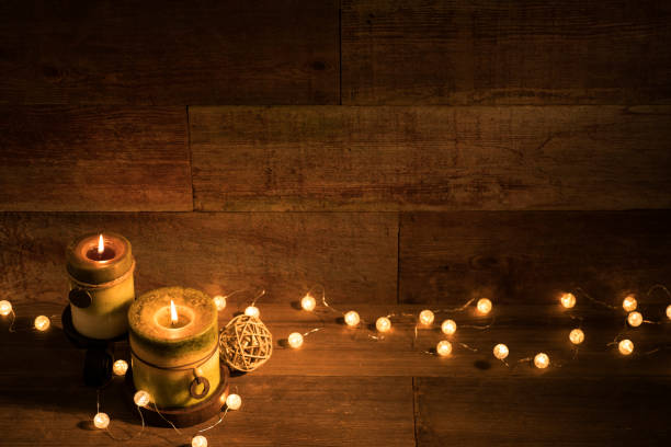 istock Candles with Christmas lights on retro wood background 871373182