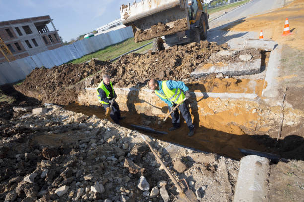 istock Workers works with shovel in a trench on pipeline construction site 871376200