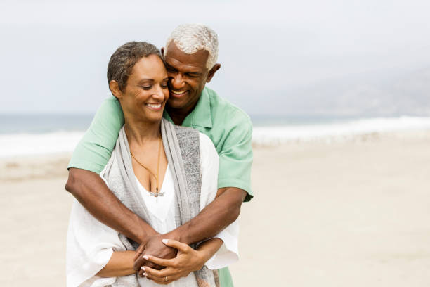 istock Mature couple embracing on beach. 871379348