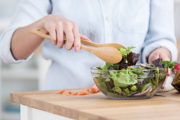 istock Unrecognizable woman tosses salad in kitchen 871381516