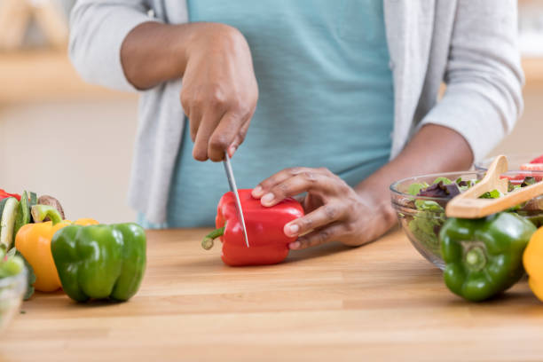 istock Unrecognizable woman slices vegetables in kitchen 871381544
