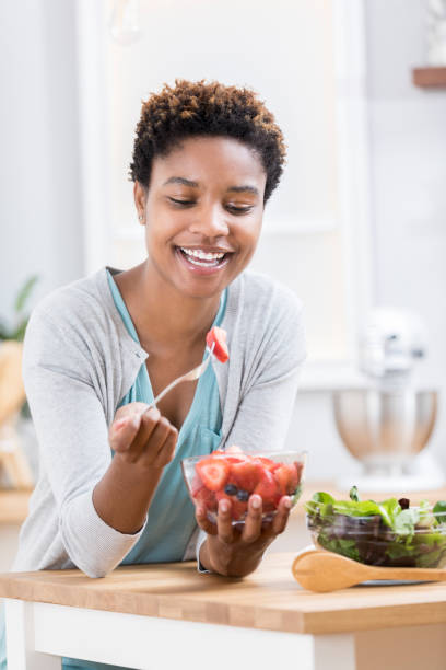 istock Young woman enjoys fresh produce in kitchen 871381546