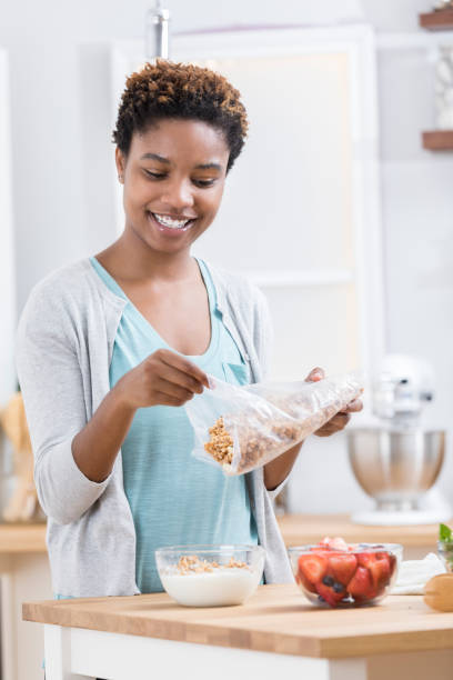 istock Young woman prepares parfait in kitchen 871381556
