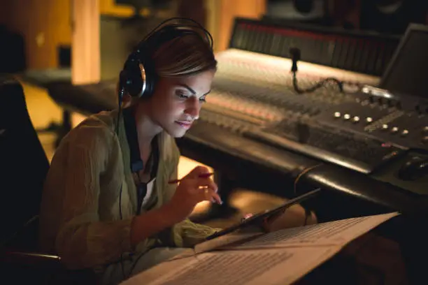 Young musician writing her next song in a music studio.