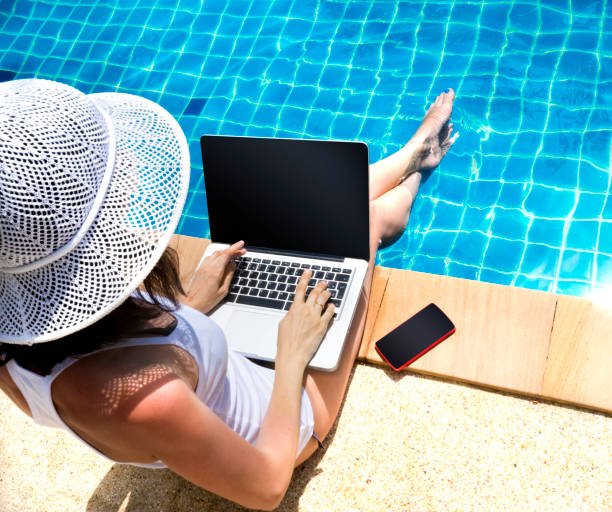 istock Woman working laptop near the poolside 871387692