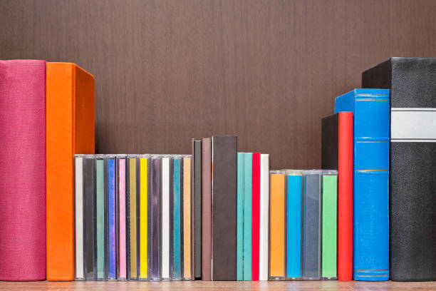 stack of colorful books, cd and cassettes in the book self - dvd stack cd movie imagens e fotografias de stock